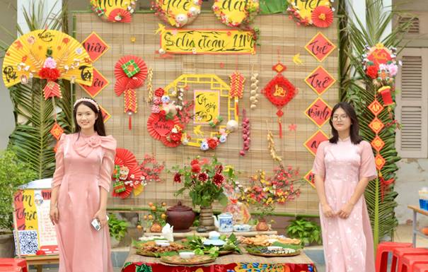 Description: Two women standing in front of a table with food  Description automatically generated