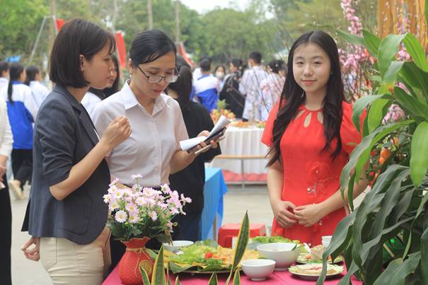 Description: A group of women standing around a table with food  Description automatically generated